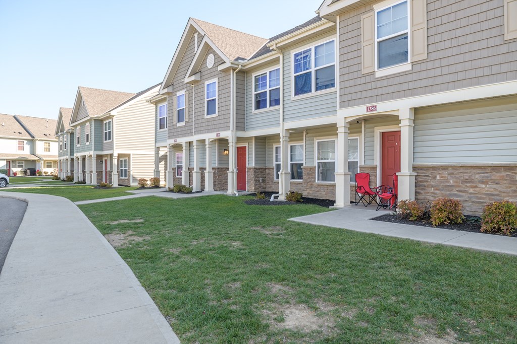 a row of houses with red doors on a sidewalk