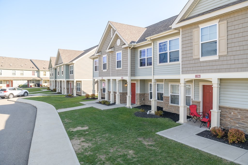 a row of houses with red doors on a sidewalk