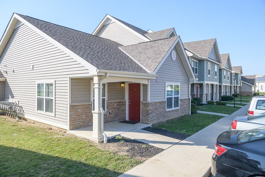 a row of houses with cars parked in front of them