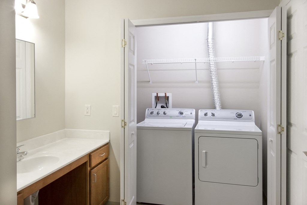 an empty laundry room with a washer and dryer in it and a sink