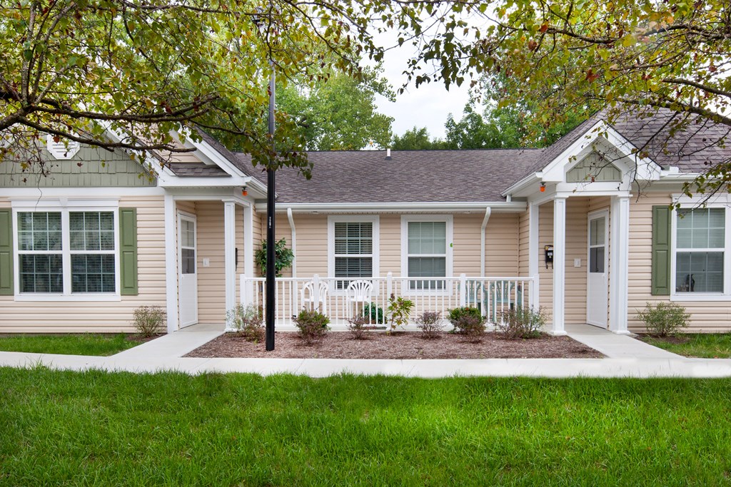 a house with a porch and a tree in front of it
