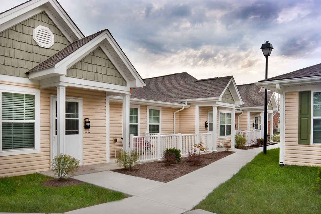 a row of townhomes with a sidewalk and grass