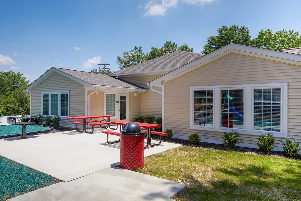 a patio with a picnic table and a fire hydrant in front of a house