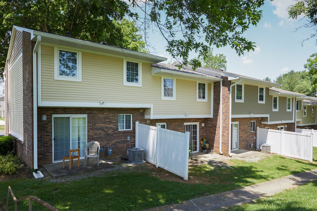a yellow house with a white fence in front of it