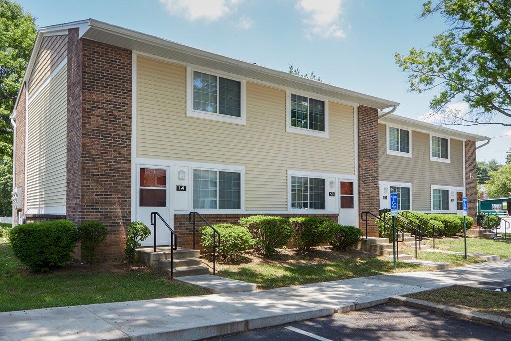 a yellow house with a sidewalk in front of it