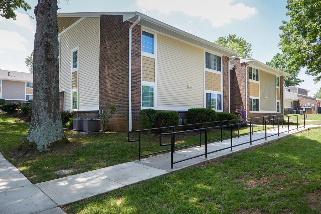 an apartment building with a sidewalk in front of it