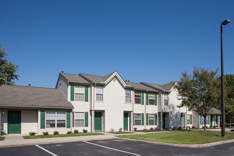 a row of houses with green doors and white siding