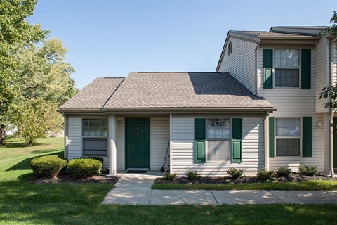 a white house with green shutters and a sidewalk