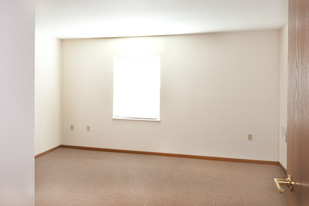 an empty room with a window and a door