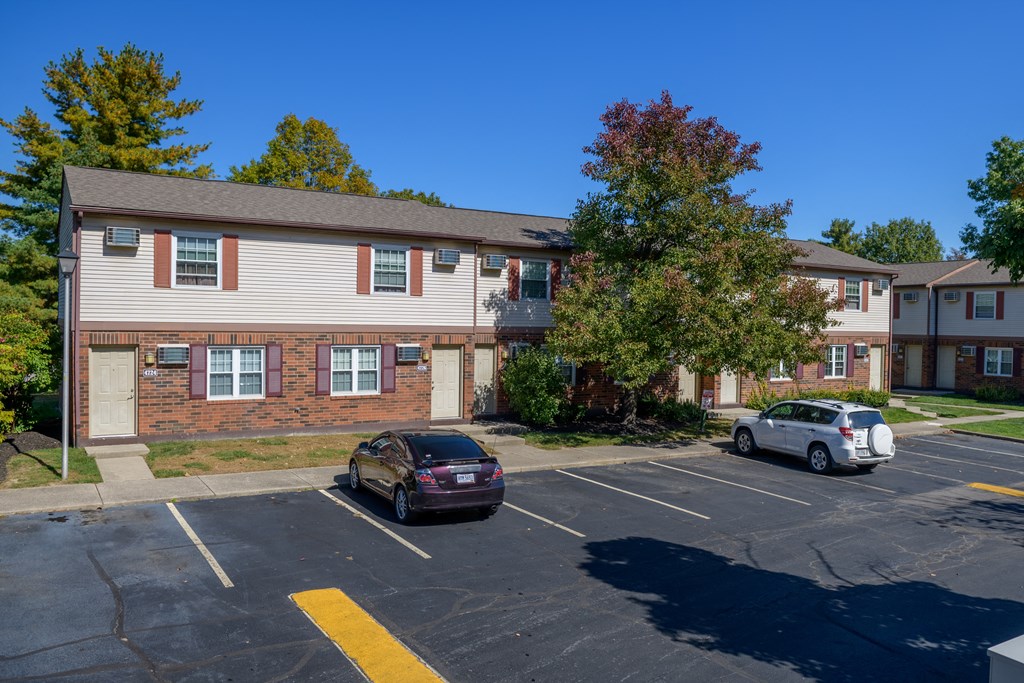 an apartment building with cars parked in a parking lot