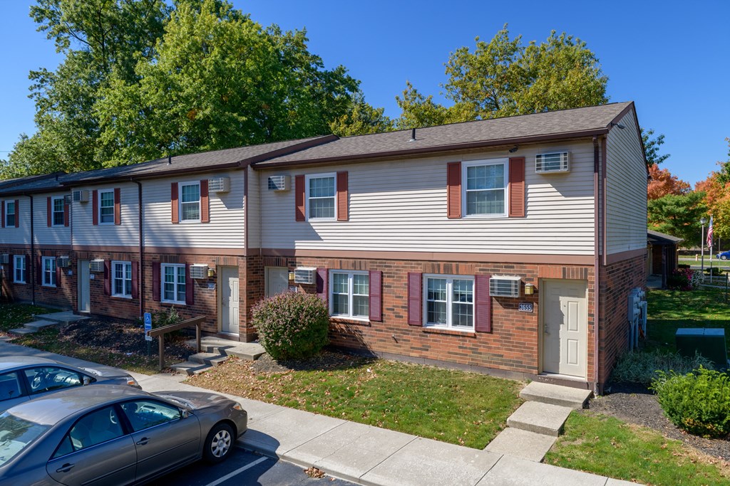 a white house with red shutters and a sidewalk