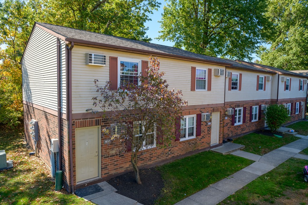 a side view of a house with a yard and a sidewalk