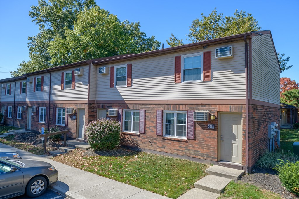an apartment building with a car parked outside of it