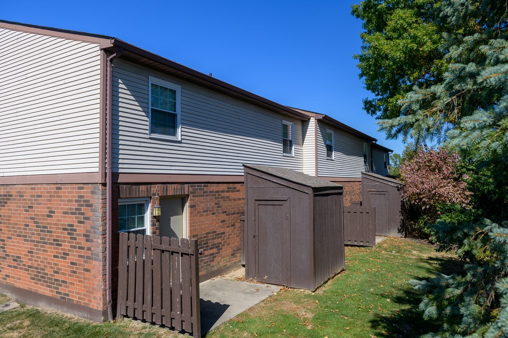 a side view of a house with a wooden fence