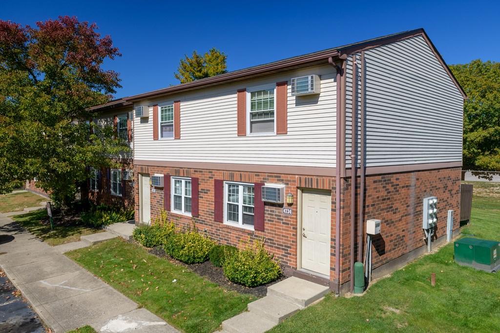 a brick and with a white door and white siding