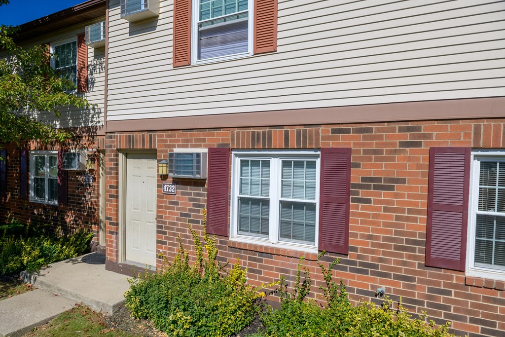 the front of a brick house with a white door