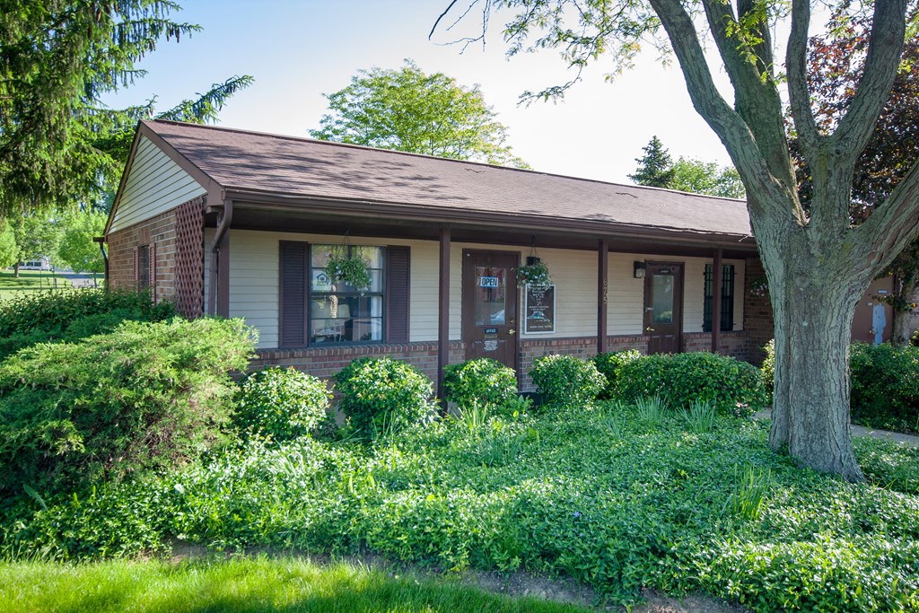 a small brick house with a tree in front of it
