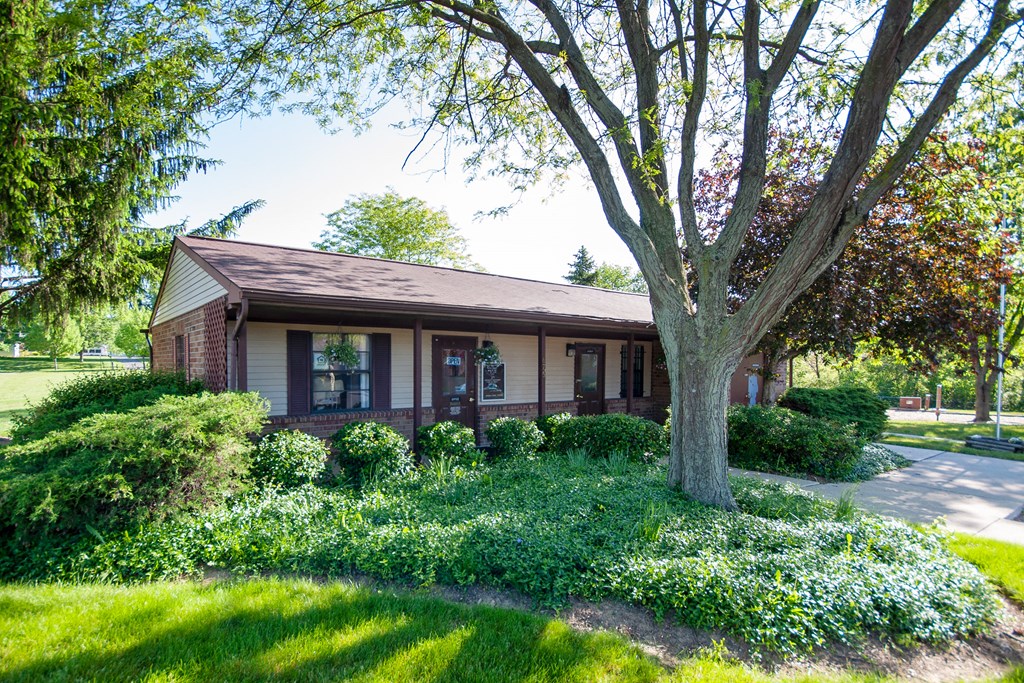 the front of a house with a tree in the yard