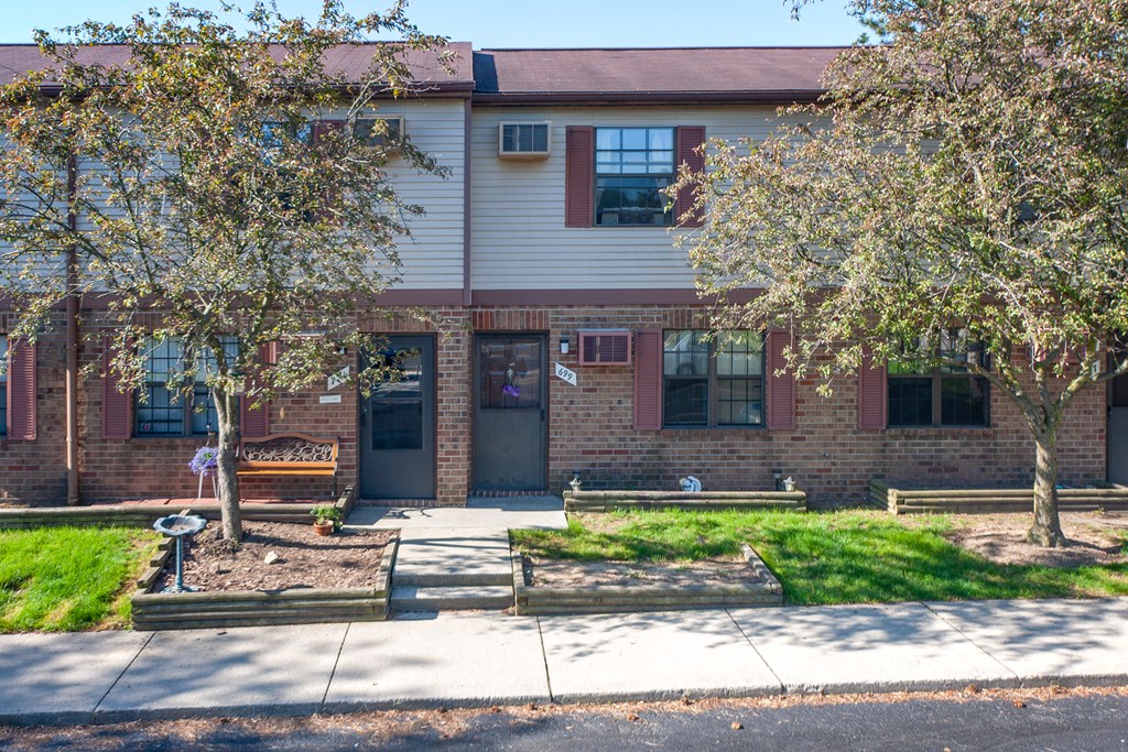 an apartment building with a sidewalk and trees