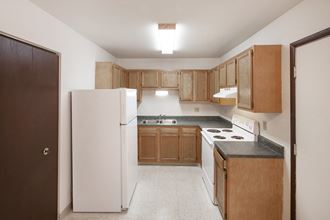 a kitchen with wood cabinets and white appliances and a refrigerator