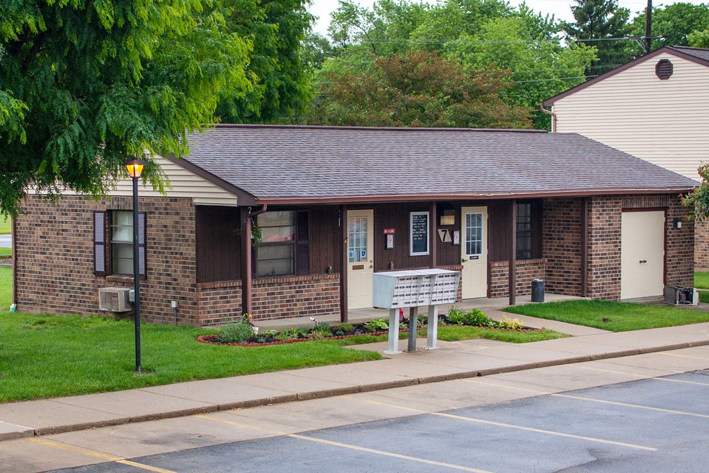 a small brick building with a sign in front of it