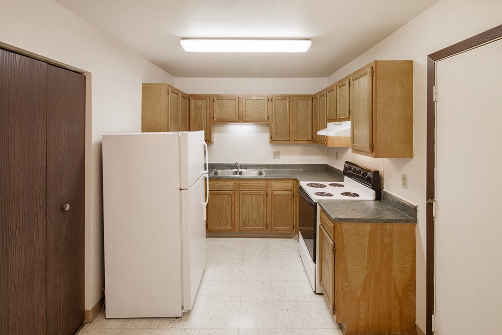 a kitchen with white appliances and wooden cabinets
