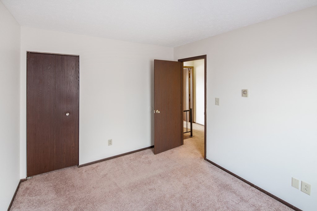 a bedroom with a closet and a door to a hallway