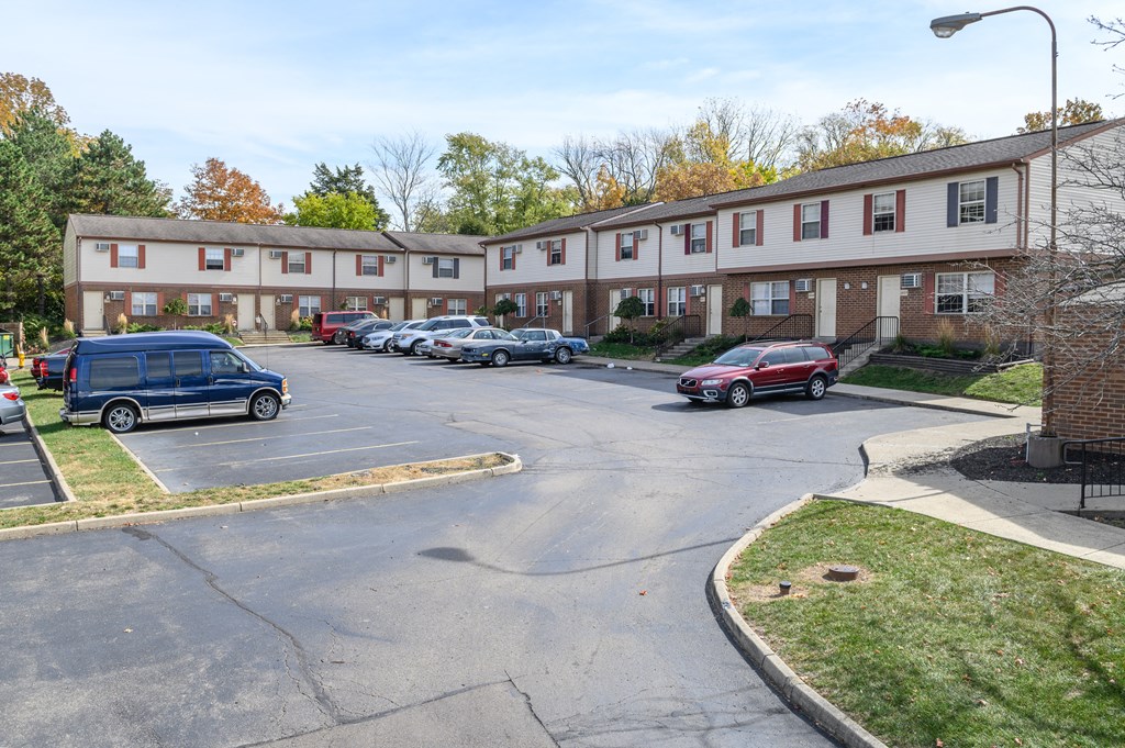 a parking lot with cars in front of an apartment building
