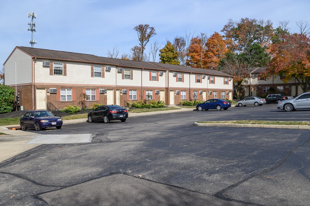 an apartment building with cars parked in a parking lot