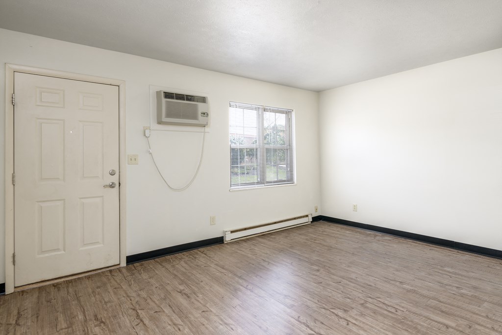 an empty room with a door and a window and a air conditioner