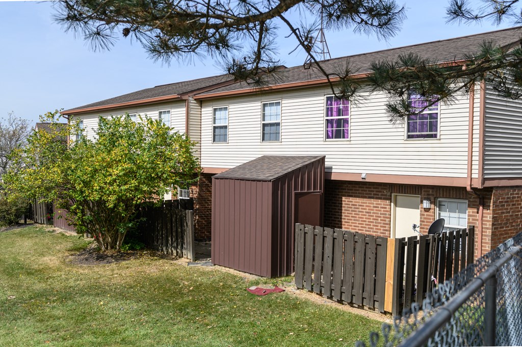 the side of a house with a fence and a gate