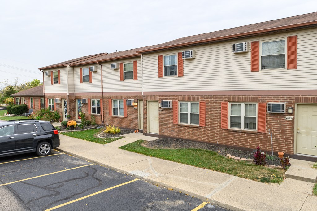 an apartment building with a car parked in a parking lot