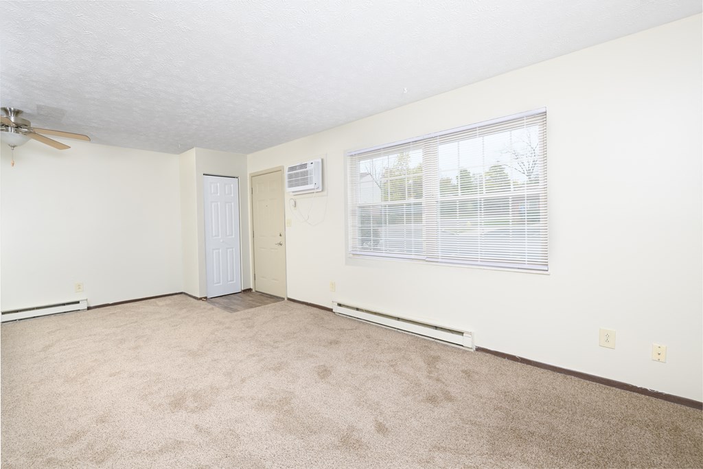 an empty living room with a window and a door