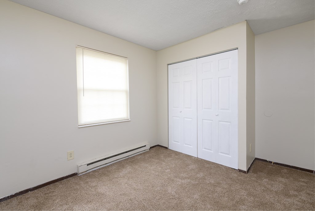 an empty room with a white door and a window