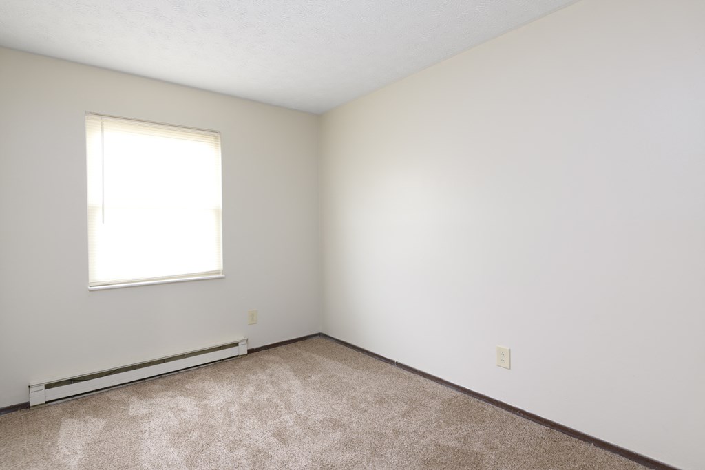 an empty room with white walls and a window