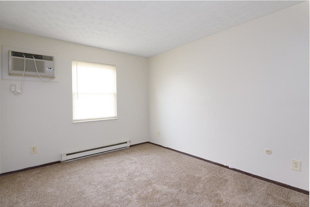 an empty room with white walls and a window