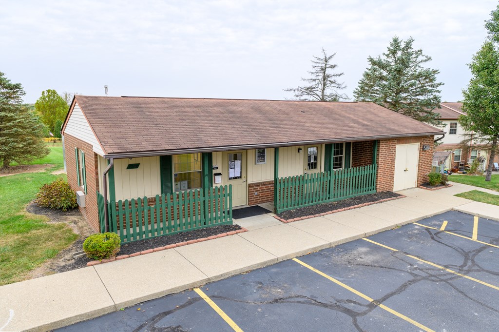 the front of a house with a green fence