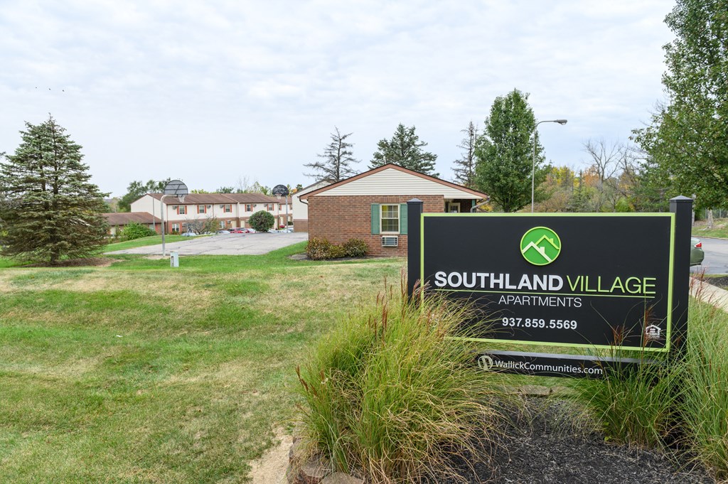 a sign for southland village with a building in the background