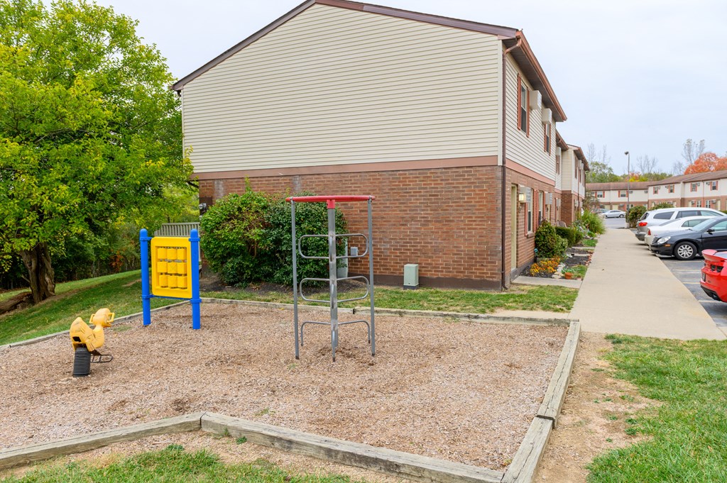 a playground in front of a building with a yellow fire hydrant
