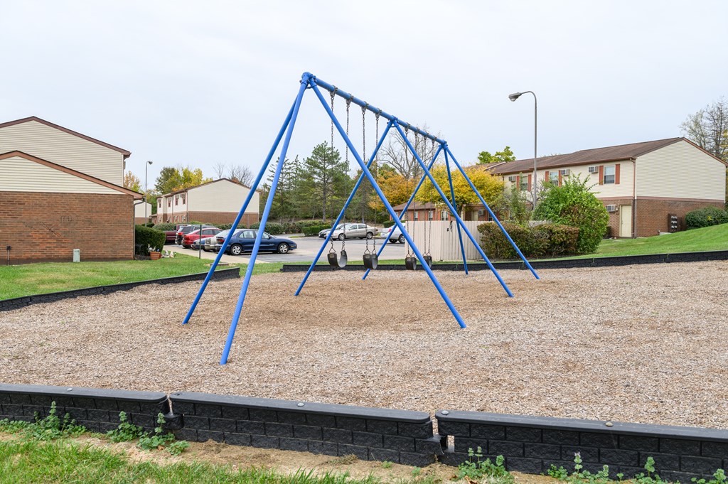 a blue swing set on a playground in a residential area