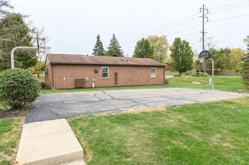 a small brick building on the corner of a parking lot