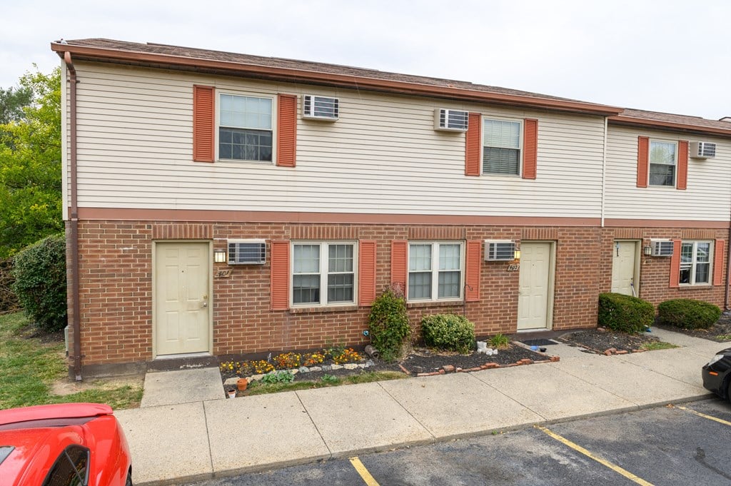 the front of a brick building with two doors and a parking lot