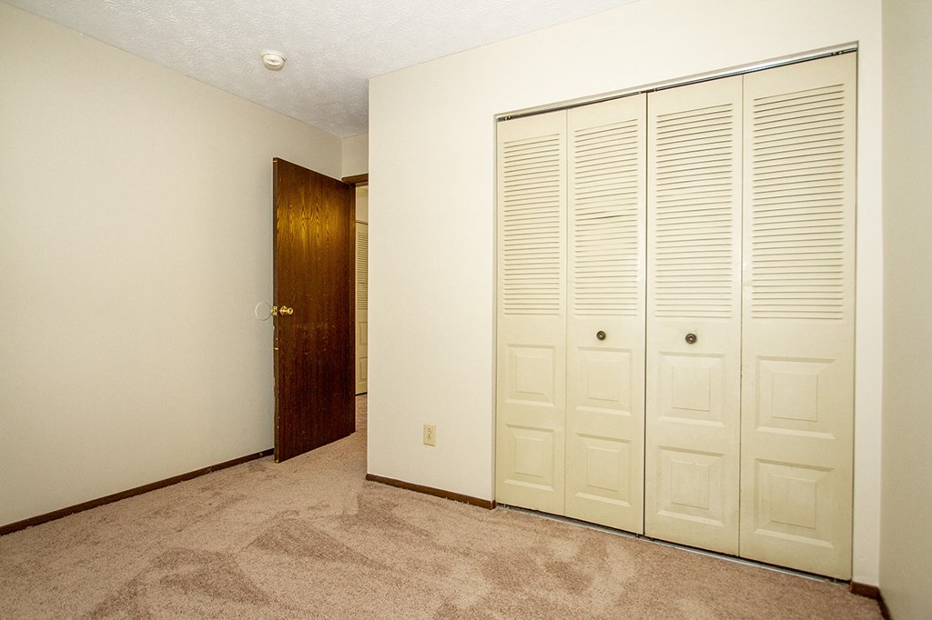 a bedroom with two closets and a door to a hallway