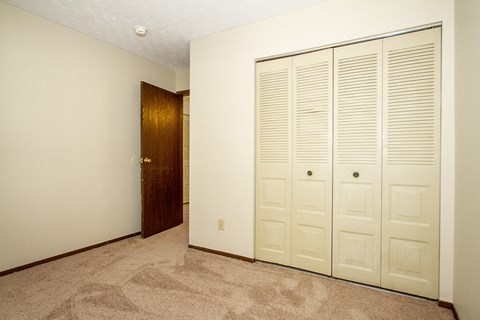 a bedroom with two closets and a door to a hallway
