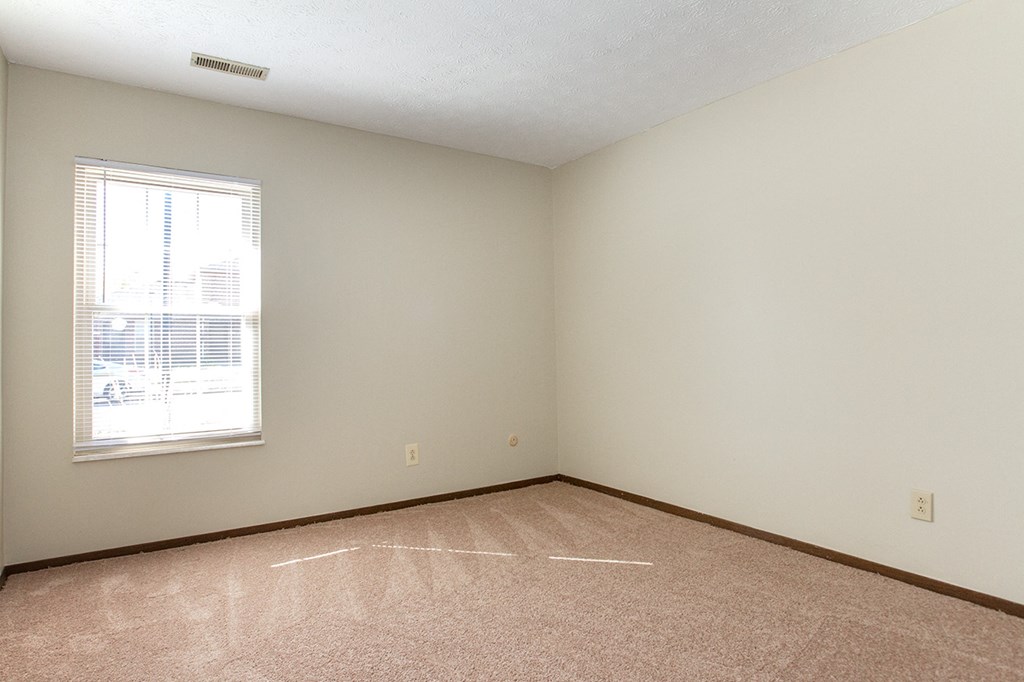 an empty room with a window and a tiled floor