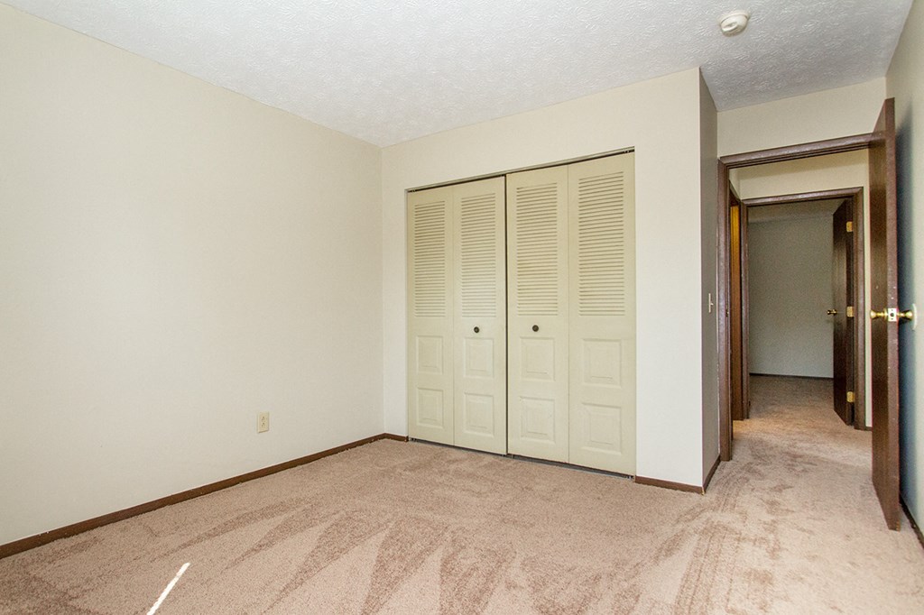 an empty living room with a door to a closet