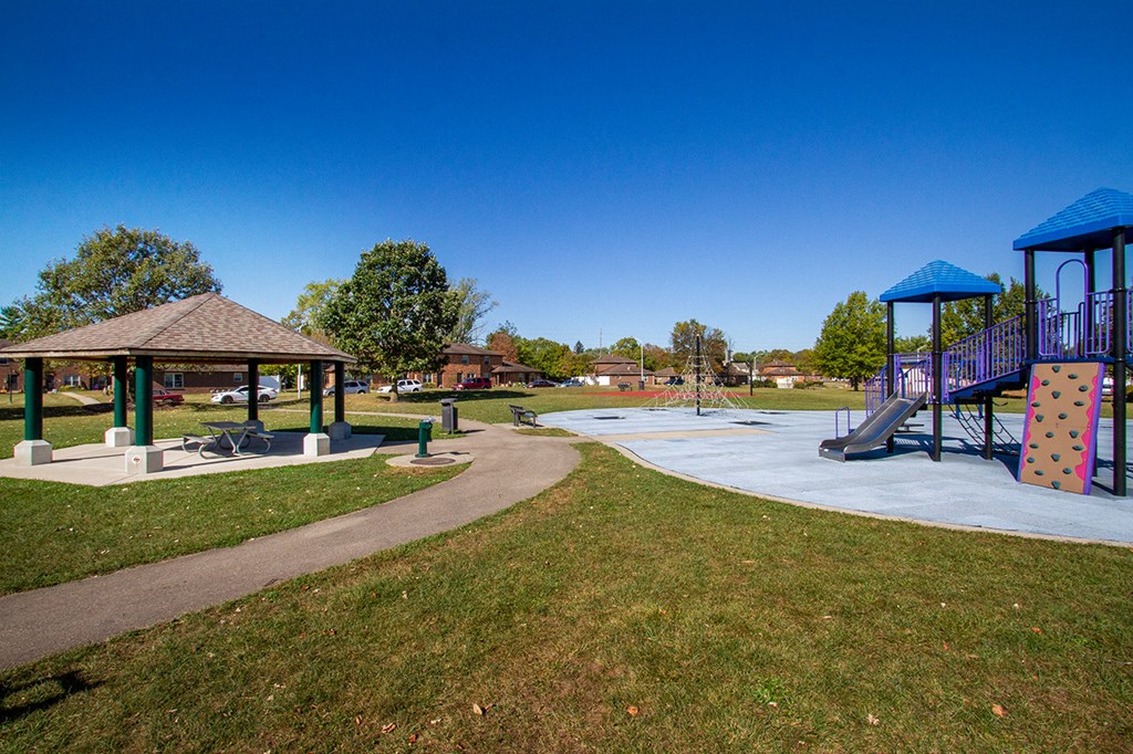 a playground with a pavilion and slides in a park