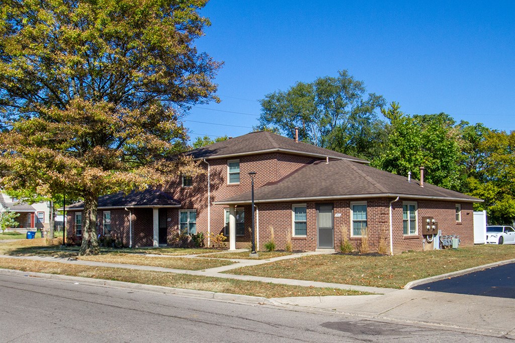 a brick house on the corner of a street