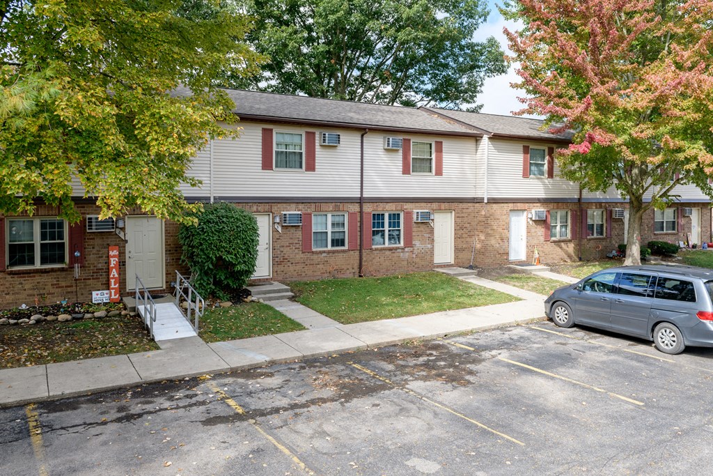 the front of a house with a car parked in the driveway