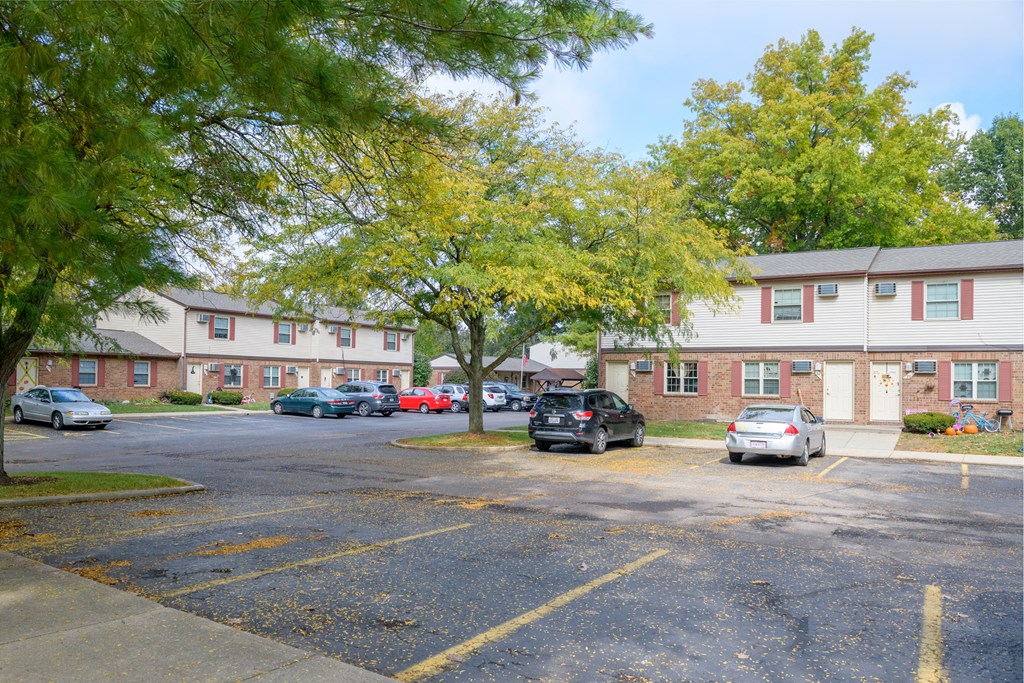 a parking lot with cars in front of an apartment building